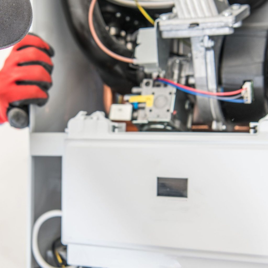 Technician opening a furnace to inspect its interior